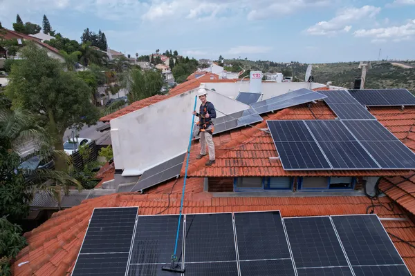 מבט אווירי על עובד מנקה פאנלים בשכונת מגורים